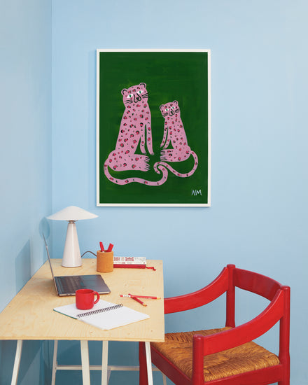interior image of the "Leopards in Pink Poster" hanging on a blue wall in a home office