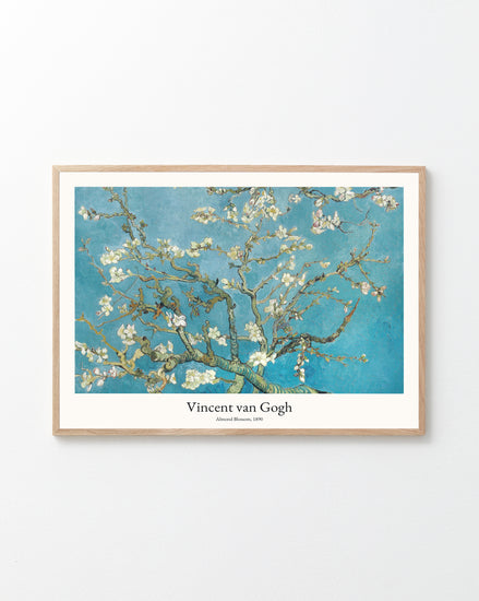 The Almond Blossom by Vincent van Gogh Poster hangs on a pristine white wall, featuring blooming almond branches against a vibrant blue sky, with the title and artists name elegantly displayed beneath the image.