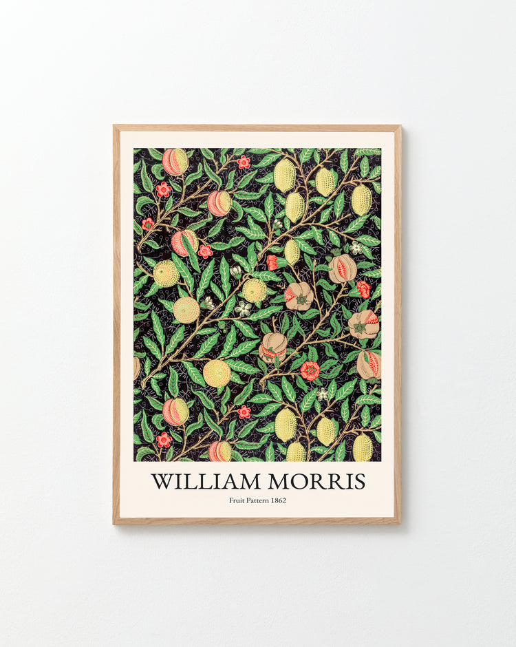 The white wall is beautifully decorated with a Fruit Pattern by William Morris Poster, featuring colorful fruits and leaves on a bold black background.