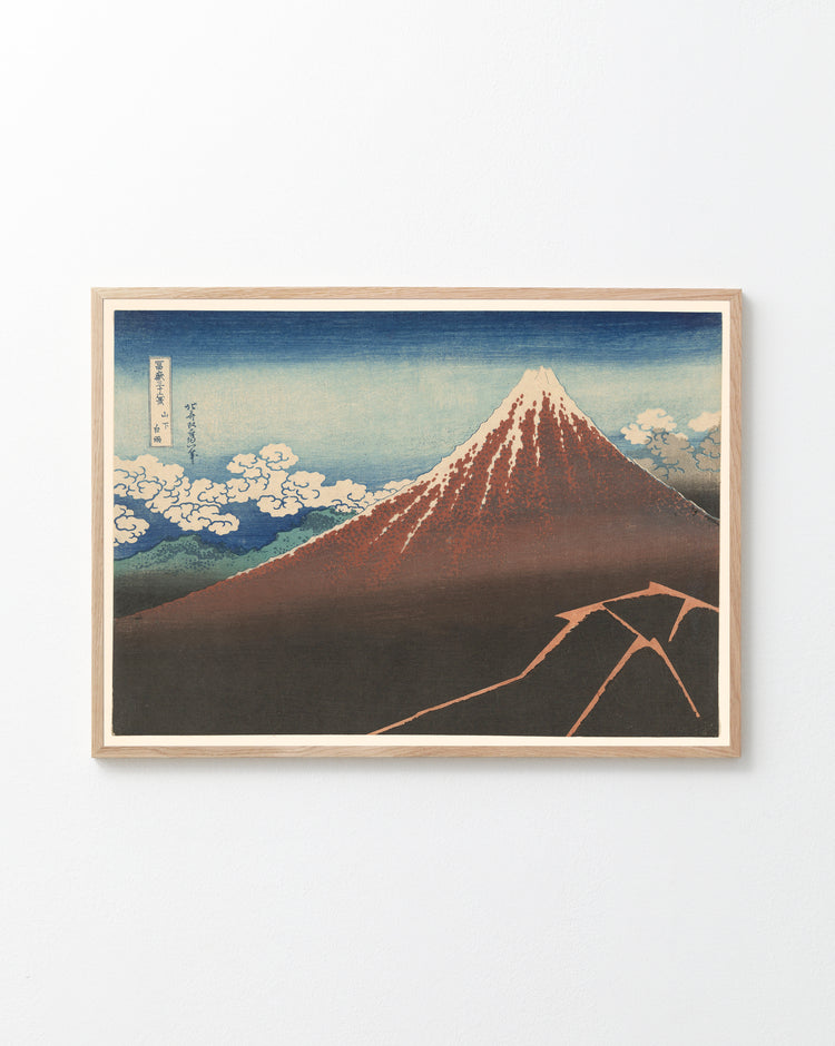 The Fuji above the Lightning by Katsushika Hokusai Poster showcases a snow-capped Mount Fuji under a blue sky with clouds, inspired by iconic Japanese art. The artwork uses serene blue, earthy brown, and crisp white tones.