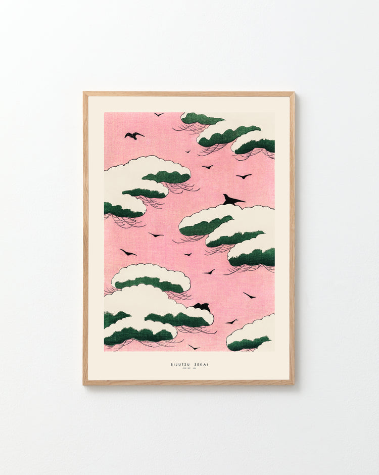 The Pink Sky by Watanabe Seitei poster captures the essence of Japanese woodblock prints with stylized green and white clouds, black birds, and a pink sky. The minimalist design and light wood frame enhance tranquility, making it an elegant addition to any home decor on a plain white wall.