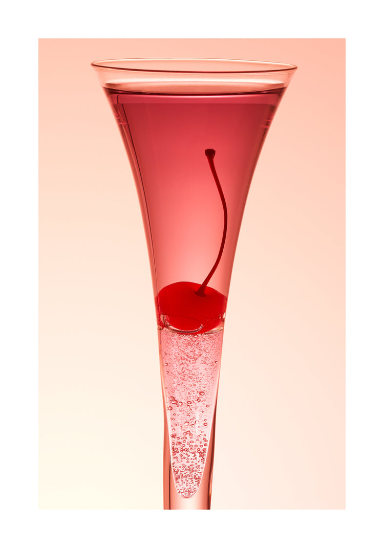 An eye-catching still life photograph showcasing a close-up of a drink adorned with a delectable cherry against a vibrant pink background. White border.