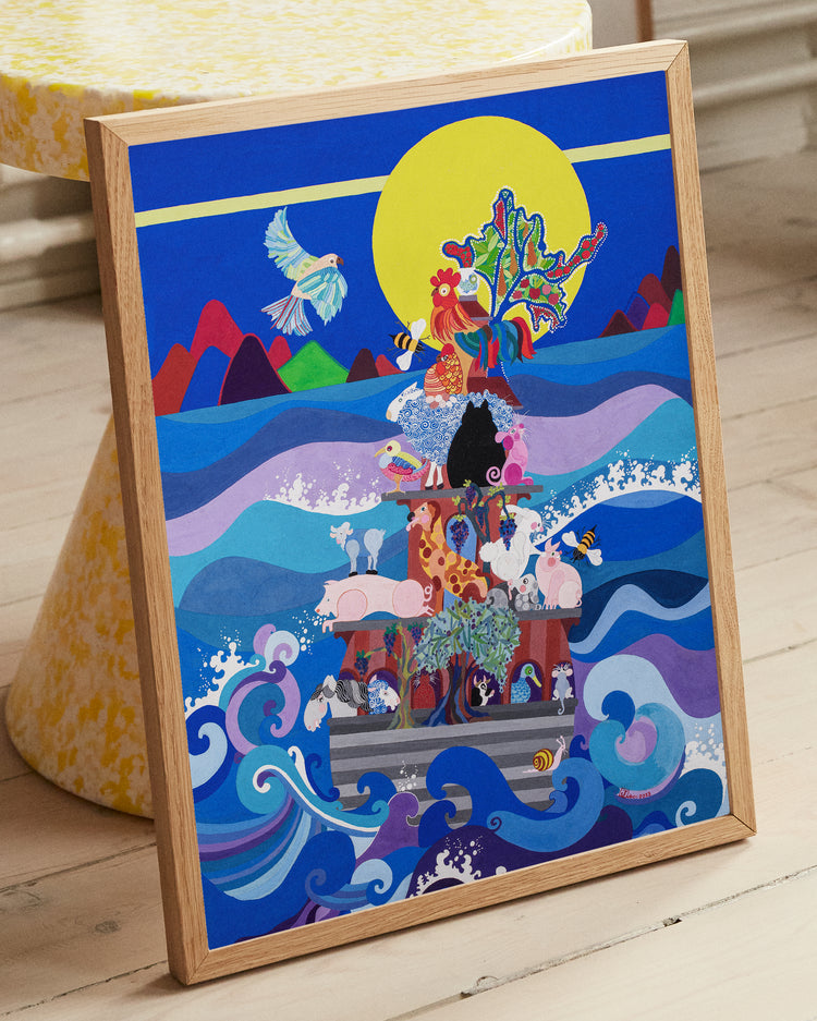 Framed poster leaning against a yellow sideboard. The poster feature a painting that shows farmyard animals on an ark, humorously sailing on the ocean. Jean saw the ark as an environmental symbol and a metaphor for aiding nature. The painting includes a vine with grapes and an olive tree, adding to the aquatic barnyard theme.