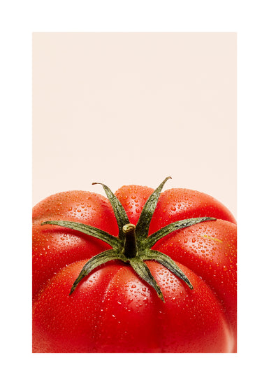 A close-up photograph features a vibrant red tomato adorned with delicate water droplets set against a clean white backdrop. White border.