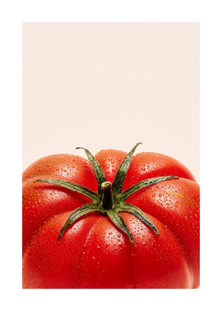 A close-up photograph features a vibrant red tomato adorned with delicate water droplets set against a clean white backdrop. White border.