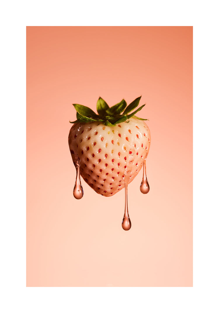 A stilllife photograph of a flawless white strawberry on a pretty pink background. White border.