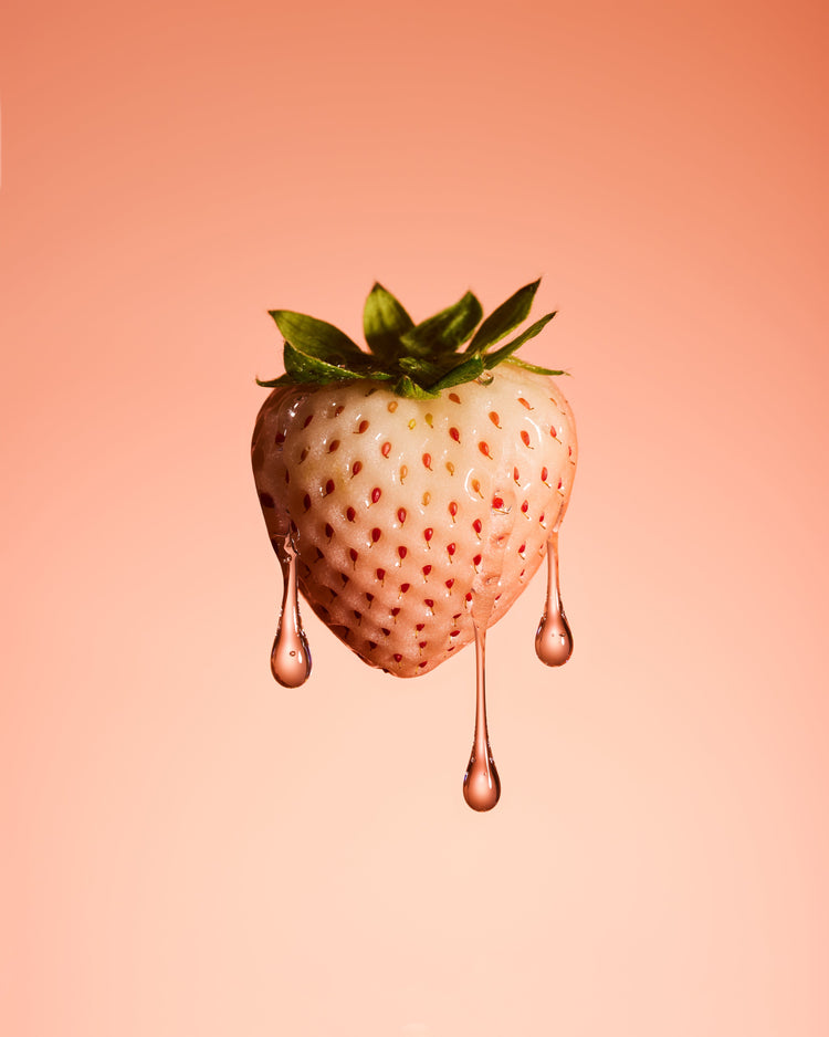 A stilllife photograph of a flawless white strawberry on a pretty pink background.