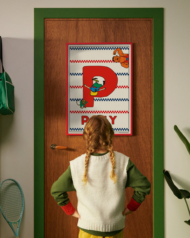 Pippi Longstocking personalised poster featuring the letter P hanging on a door, with a child curiously looking at the artwork.