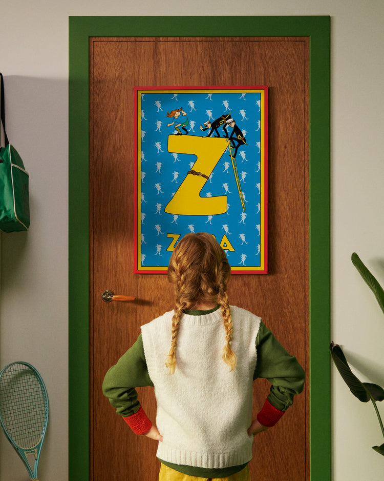 Pippi Longstocking personalised poster featuring the letter Z hanging on a door, with a child curiously looking at the artwork.