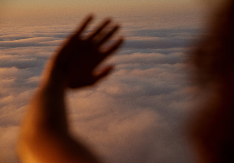 Child looking at the cloudy view from a plane window.