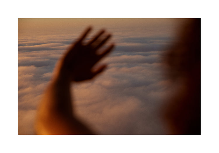 Child looking at the cloudy view from a plane window.