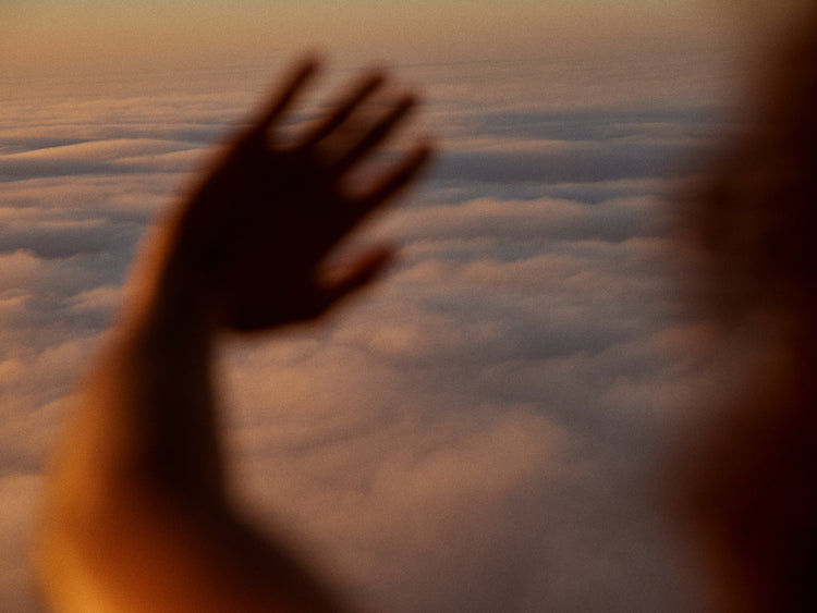 Child looking at the cloudy view from a plane window.