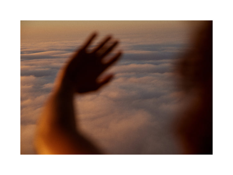 Child looking at the cloudy view from a plane window.