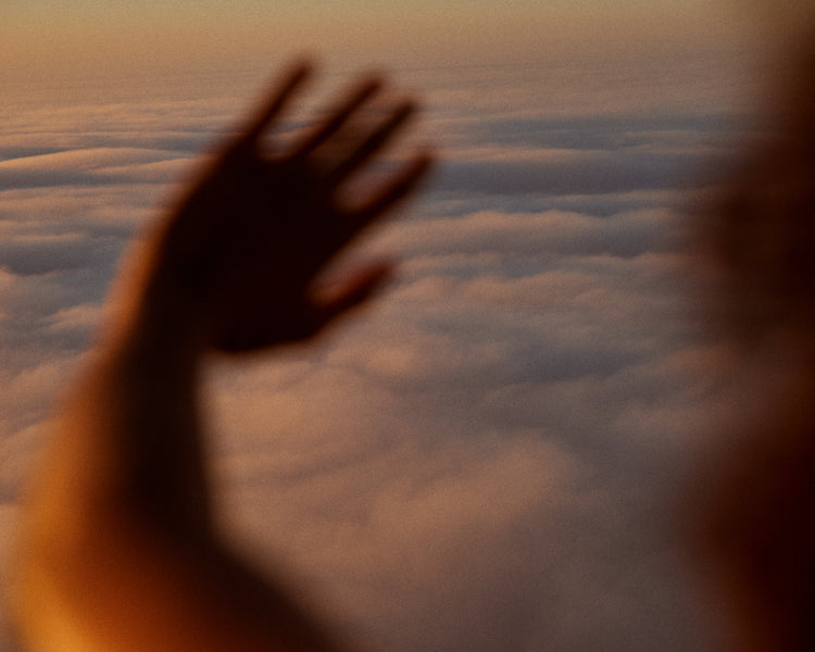 Child looking at the cloudy view from a plane window.