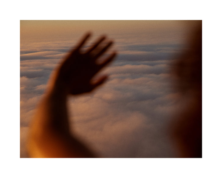 Child looking at the cloudy view from a plane window.
