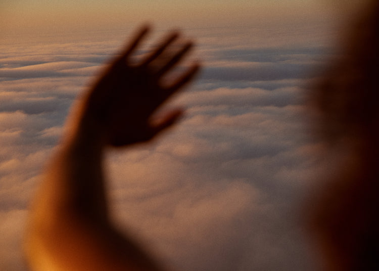Child looking at the cloudy view from a plane window.