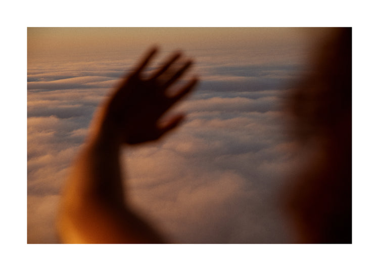 Child looking at the cloudy view from a plane window.