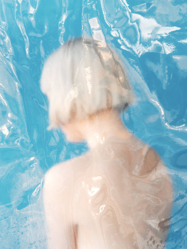 Short haired pale woman looking like a bust made from marble.