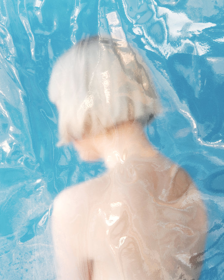 Short haired pale woman looking like a bust made from marble.