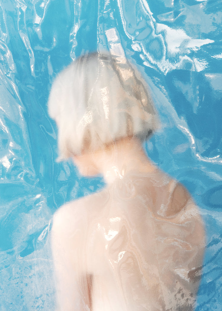 Short haired pale woman looking like a bust made from marble.
