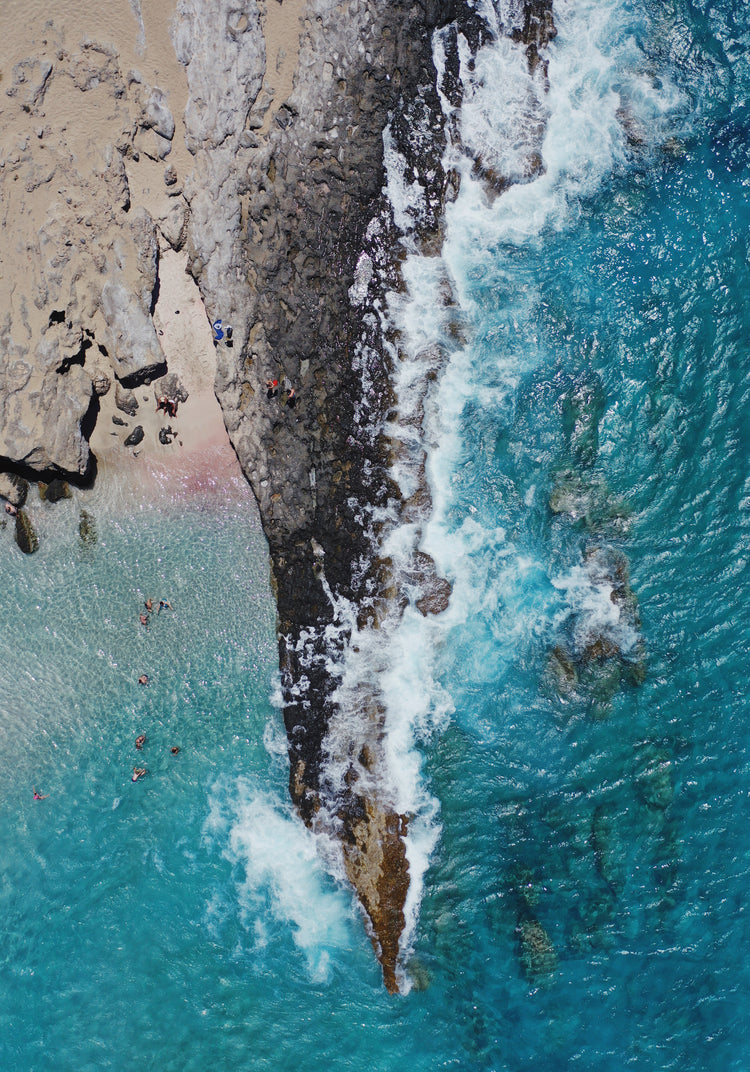 Cliff looking like a dagger cutting through a turquoise sea.