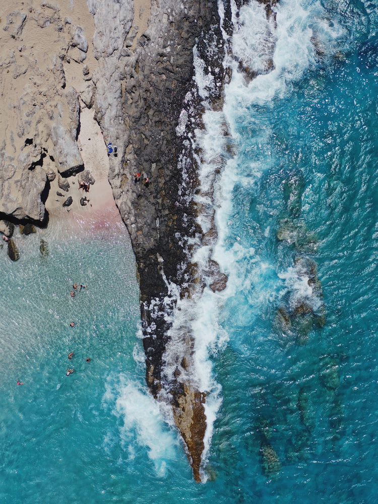 Cliff looking like a dagger cutting through a turquoise sea.