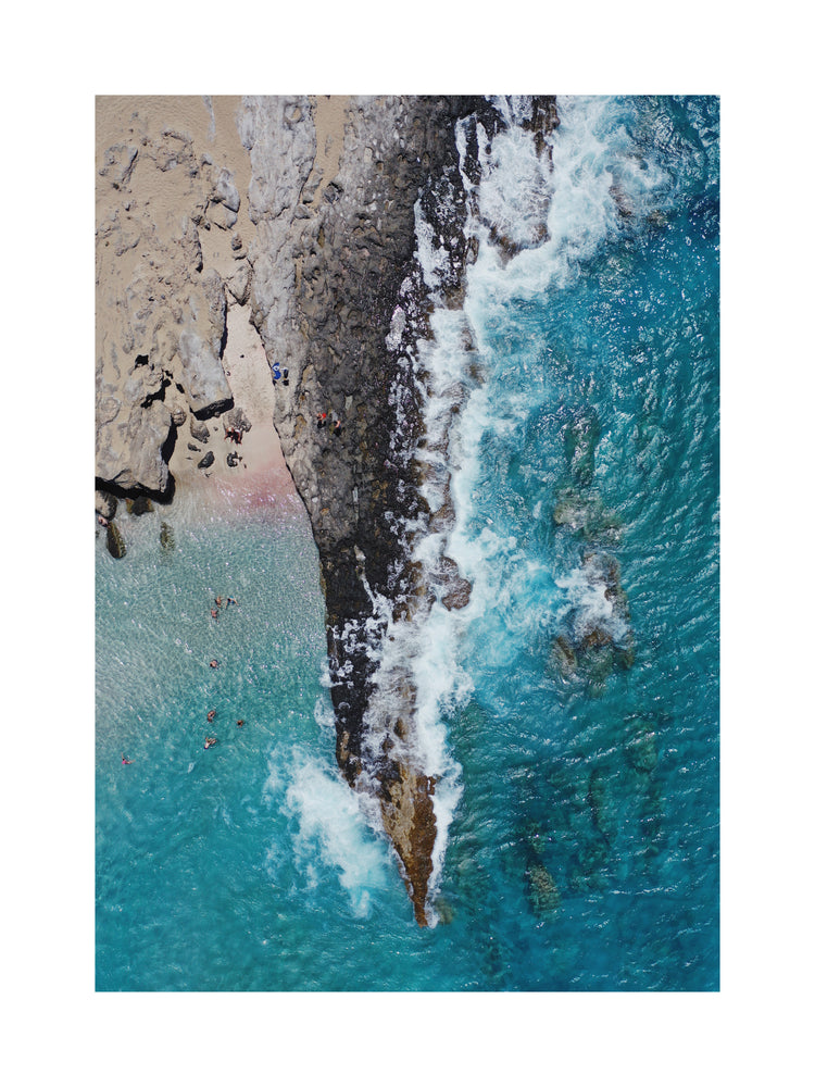 Cliff looking like a dagger cutting through a turquoise sea.