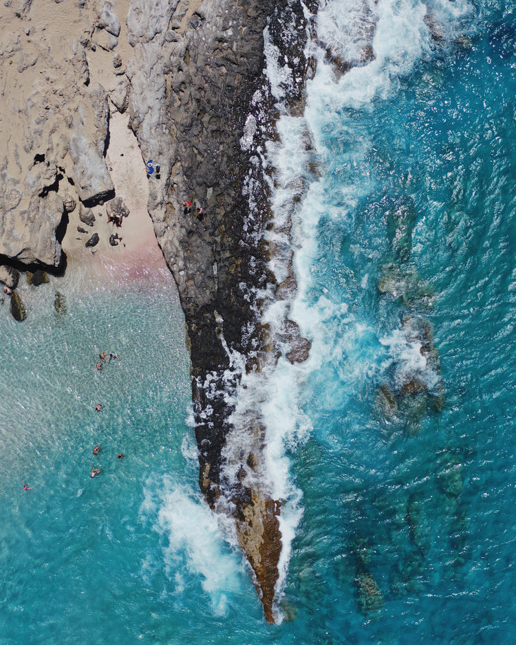 Cliff looking like a dagger cutting through a turquoise sea.