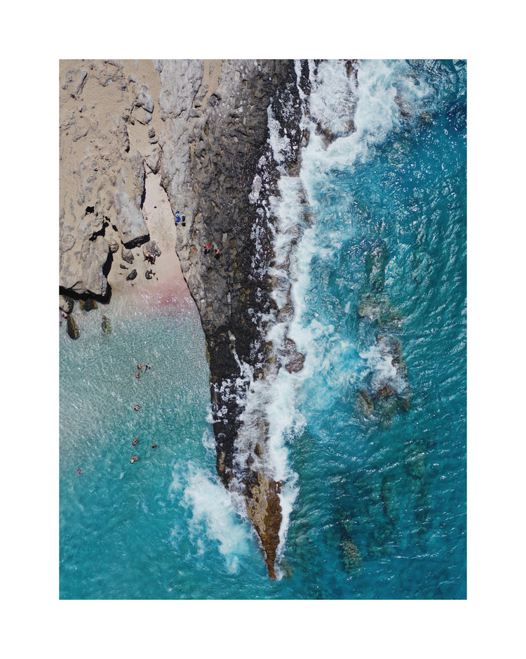 Cliff looking like a dagger cutting through a turquoise sea.