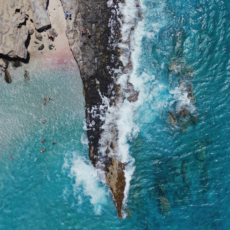 Cliff looking like a dagger cutting through a turquoise sea.