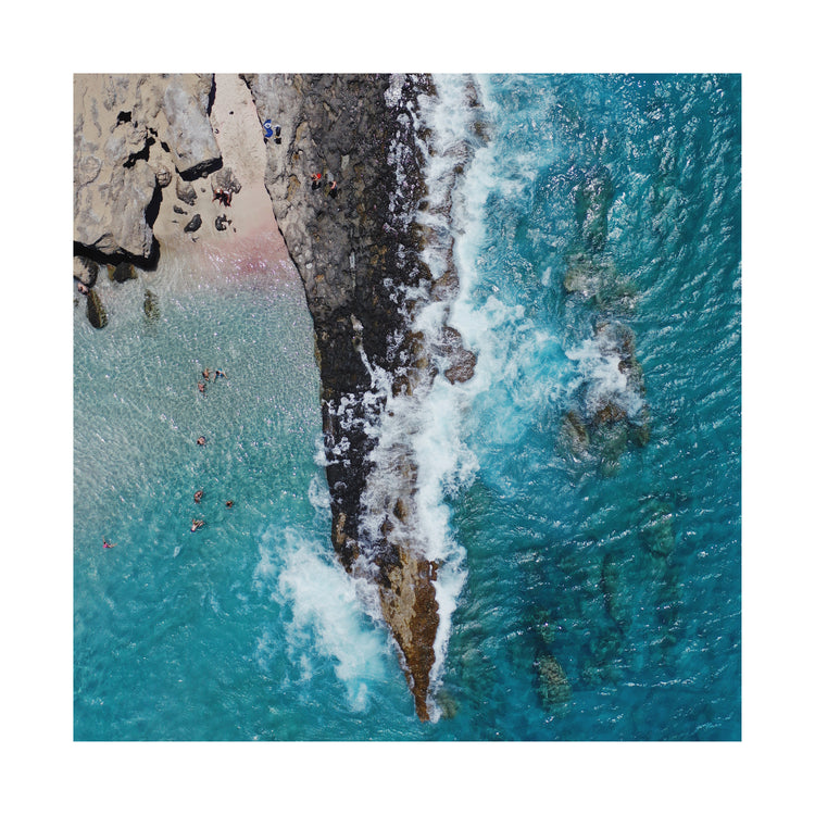 Cliff looking like a dagger cutting through a turquoise sea.