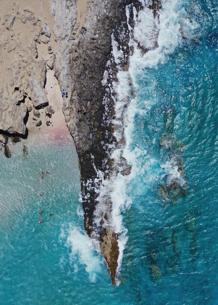 Cliff looking like a dagger cutting through a turquoise sea.