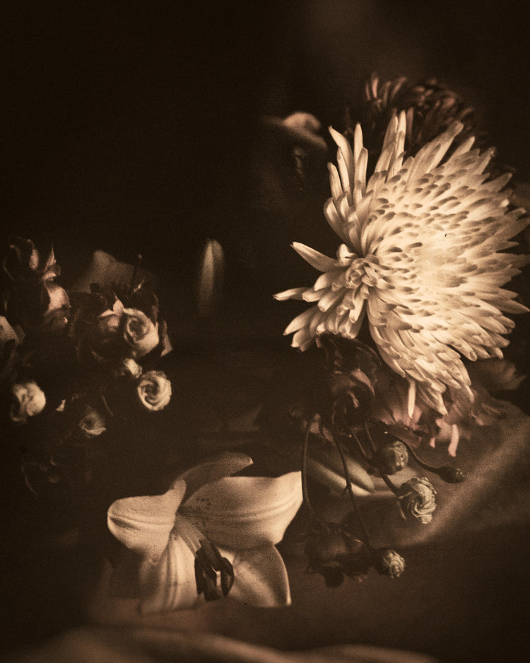 Boquete of flowers on a table photographed in sepia tone.