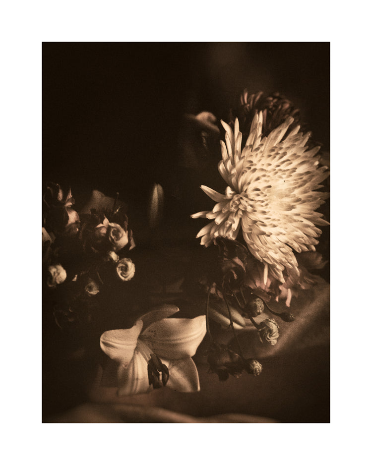 Boquete of flowers on a table photographed in sepia tone.