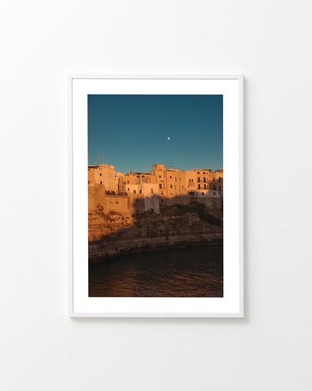Italian town with old houses illuminated by the rays of sunshine during sunset.