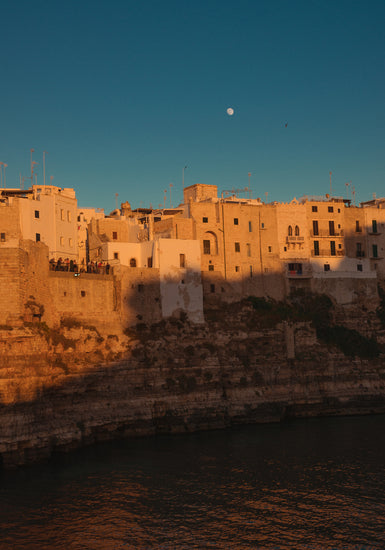 Italian town with old houses illuminated by the rays of sunshine during sunset.