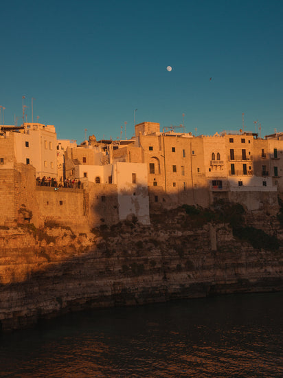 Italian town with old houses illuminated by the rays of sunshine during sunset.