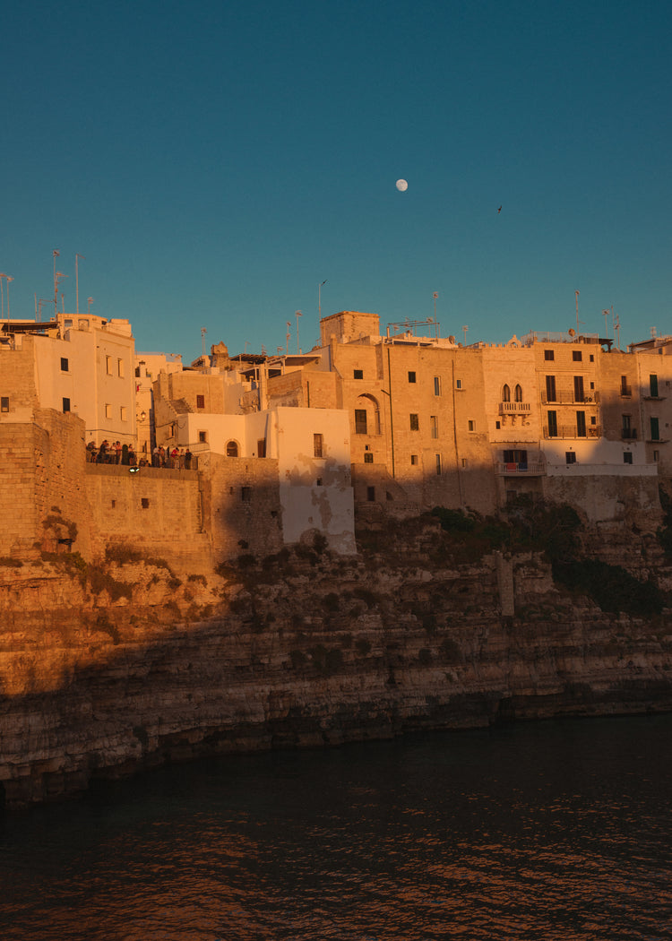 Italian town with old houses illuminated by the rays of sunshine during sunset.
