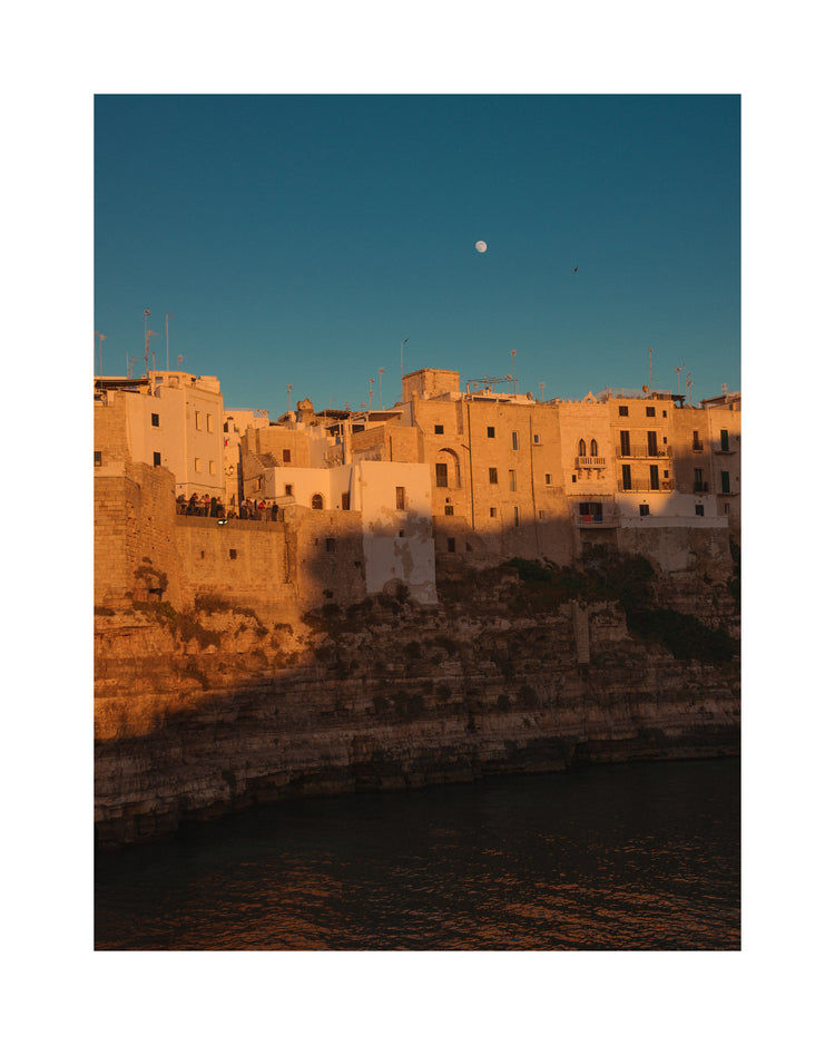 Italian town with old houses illuminated by the rays of sunshine during sunset.