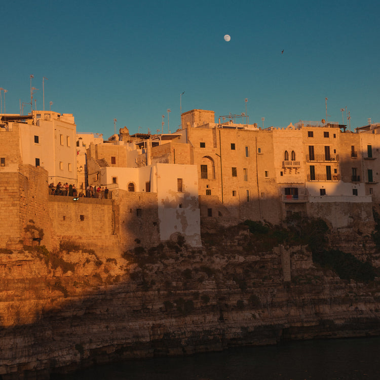 Italian town with old houses illuminated by the rays of sunshine during sunset.
