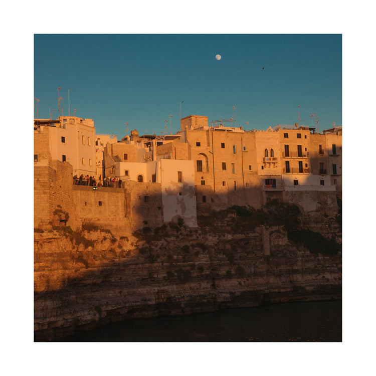 Italian town with old houses illuminated by the rays of sunshine during sunset.