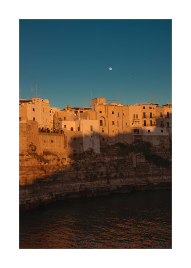 Italian town with old houses illuminated by the rays of sunshine during sunset.