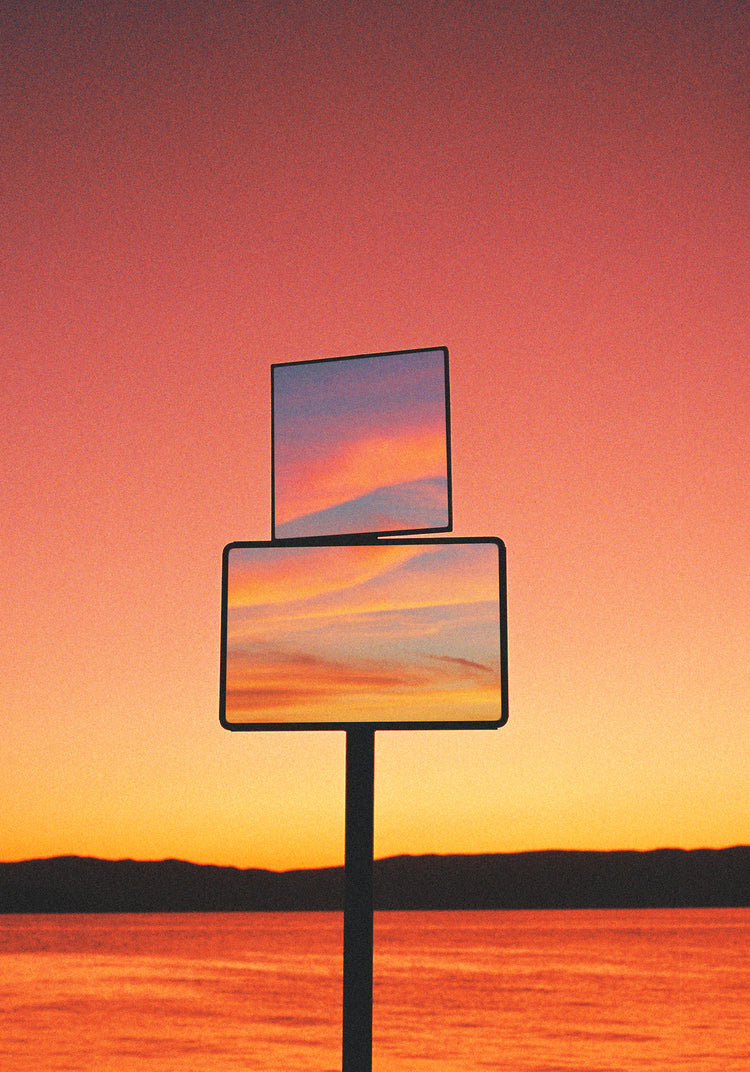 Mirrors reflecting a sunset scenery with sea and sky colored in orange and pink.
