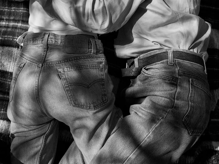 Entangled bodies of a couple lying on a picnic blanket.