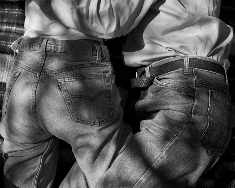 Entangled bodies of a couple lying on a picnic blanket.