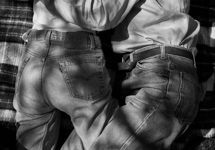 Entangled bodies of a couple lying on a picnic blanket.