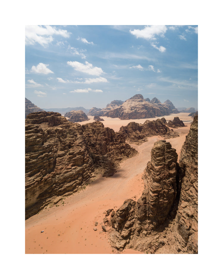 Landscape photograph with brown cliffs and rusty red dirt roads.