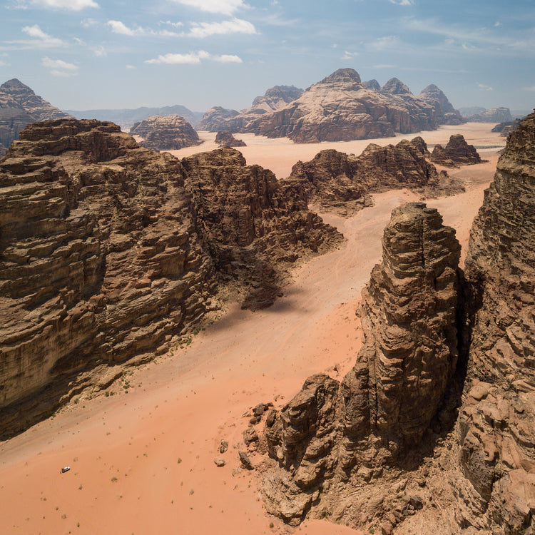 Landscape photograph with brown cliffs and rusty red dirt roads.