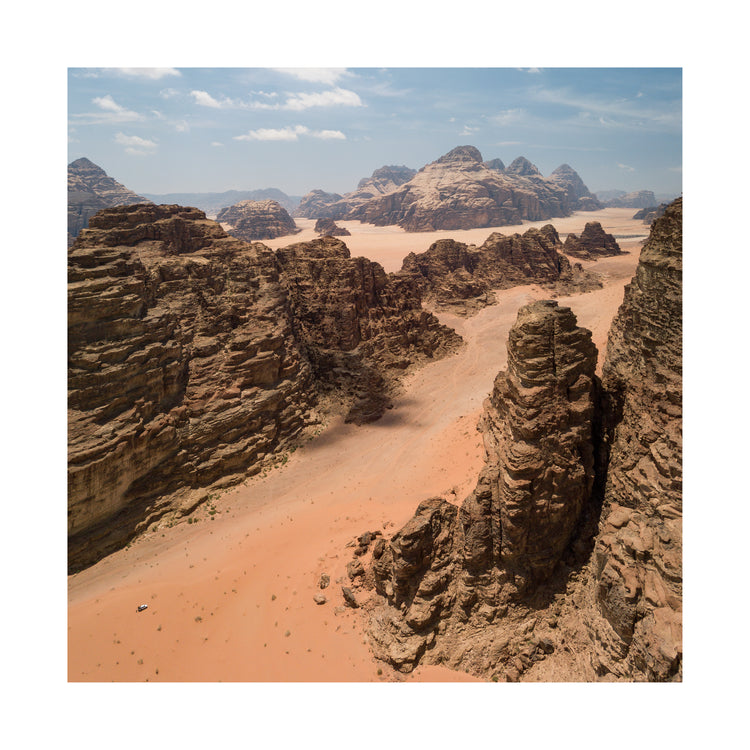 Landscape photograph with brown cliffs and rusty red dirt roads.