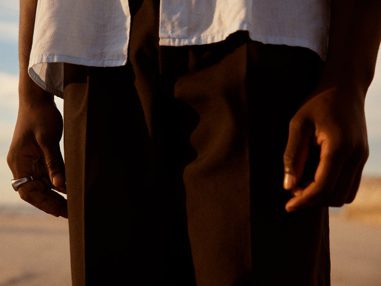Man wearing white shirt and brown slacks.